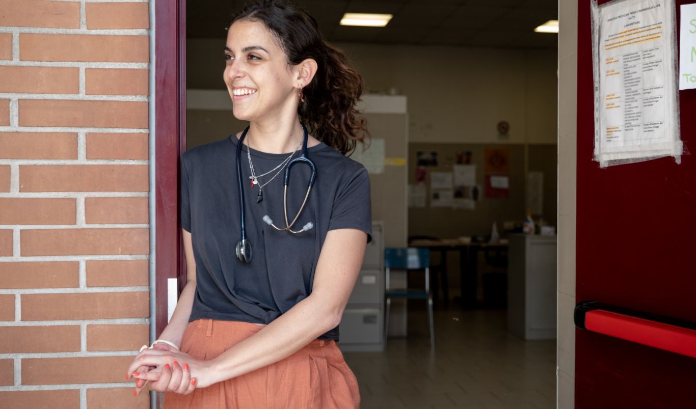 Una ragazza sul ciglio della porta di un ufficio sorride