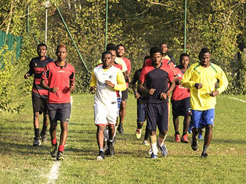 Ragazzi di origine africana corrono insieme in un campo da calcio